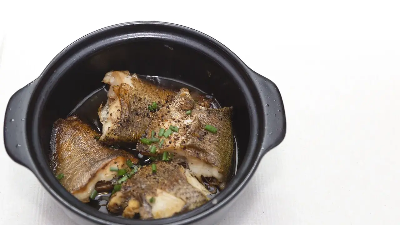 Pezzi di pesce dorato in umido, guarniti con erba cipollina, un assaggio dei piatti tipici Pescara.