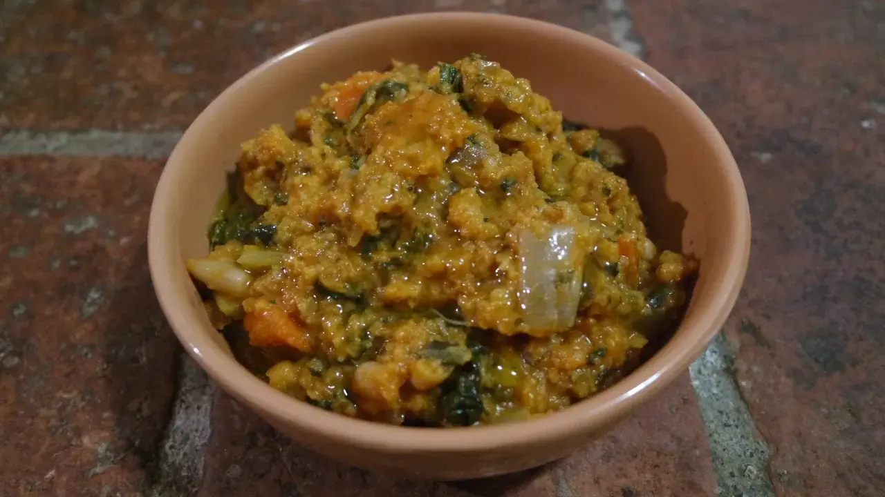 Una ciotola di ribollita senese, ricca e saporita, con pane raffermo, verdure e fagioli.