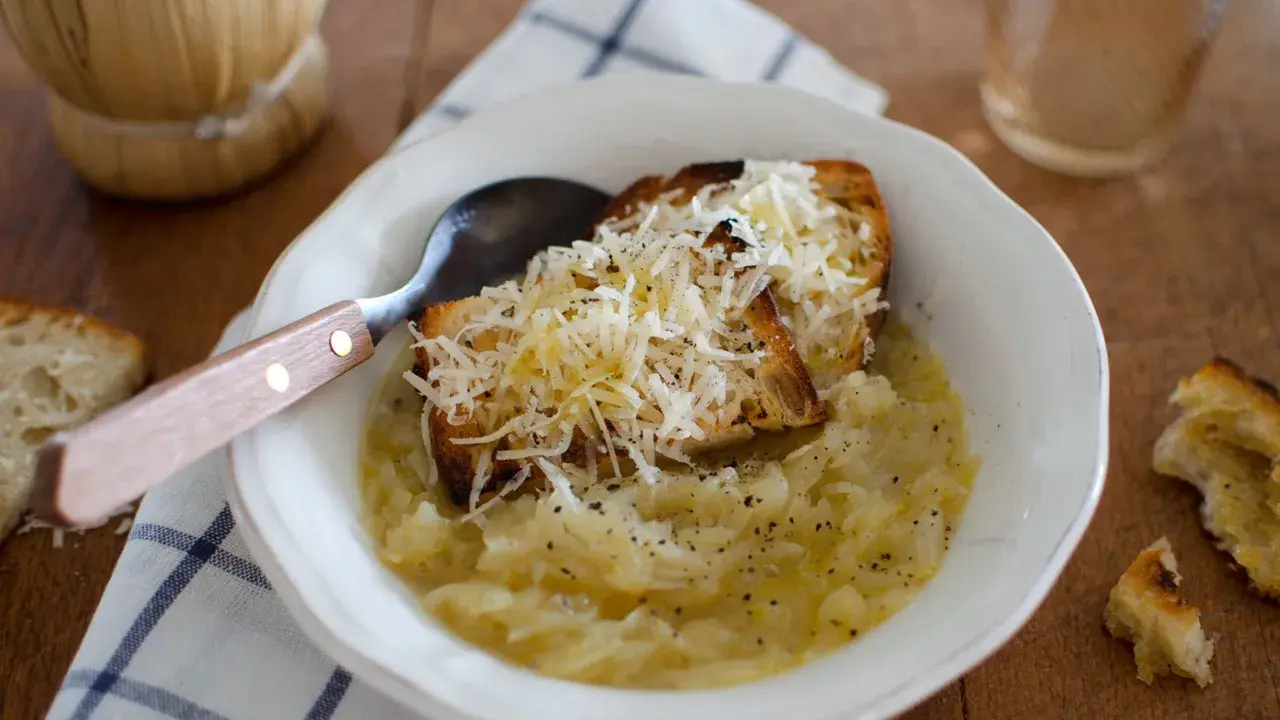 Zuppa di cipolle fumante con crostini gratinati al formaggio, un comfort food che ricorda la carabaccia.
