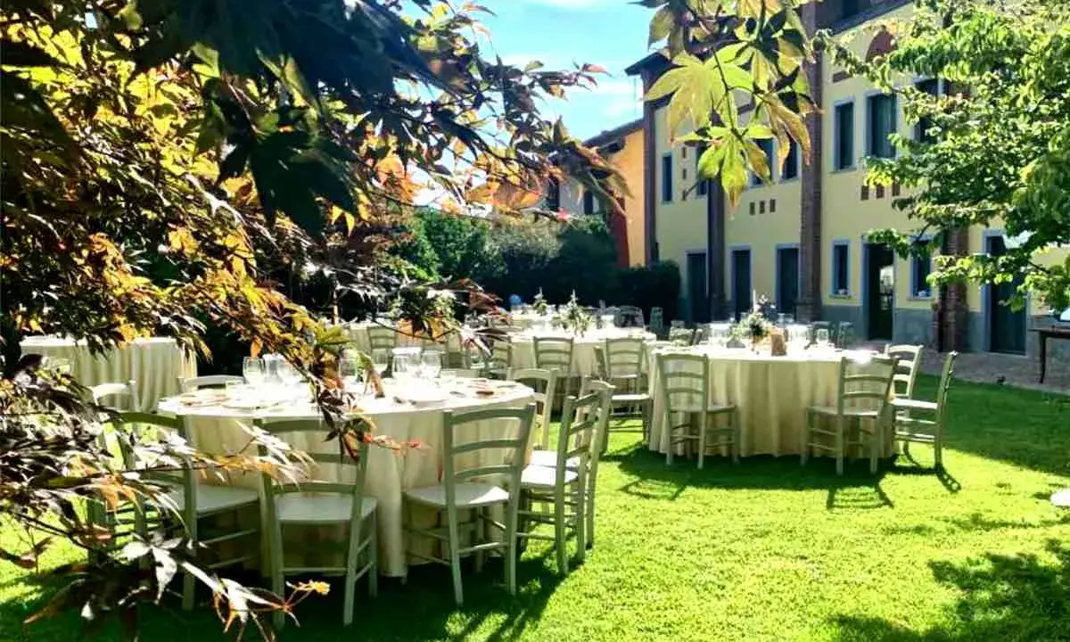 Tavoli apparecchiati in giardino, un'idea perfetta per cosa fare in campagna: un banchetto all'aperto sotto il sole.