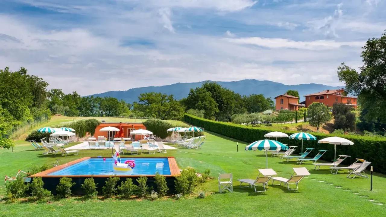 Agriturismi per bambini con piscina e gonfiabile a forma di unicorno, circondati da verde e colline.