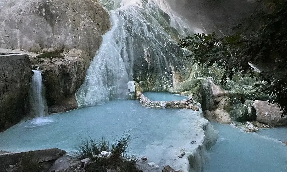 Cascate termali naturali a San Filippo, Toscana, con acque azzurre che scorrono su rocce calcaree.