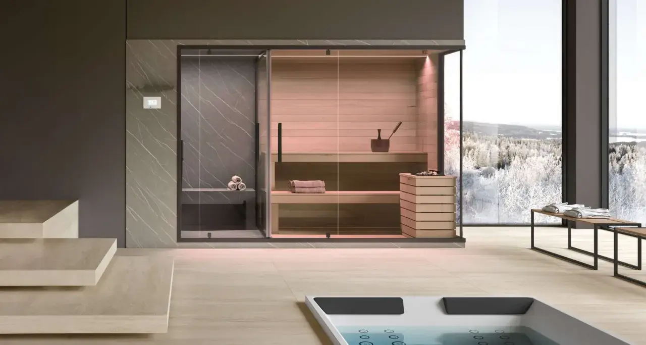 Moderna spa per famiglie con sauna in legno, doccia e vista panoramica su un paesaggio innevato.