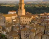Pitigliano, la "piccola Gerusalemme", si staglia su una rupe tufacea, con le sue case antiche e la torre campanaria che domina il paesaggio.