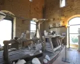 Laboratorio di scultura con attrezzi antichi e statue in marmo, che evoca la tradizione dell'alabastro toscana.