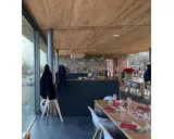 Interno di un agriturismo con tavoli apparecchiati, bancone in pietra e legno. L'agriturismo acqua terra sole offre un'atmosfera accogliente.