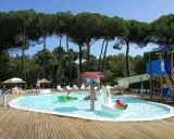 Bambini felici in piscina con gonfiabili, scivoli e giochi d'acqua. Perfetti campeggi Emilia Romagna per bambini, un'oasi di divertimento sotto i pini.