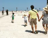 Famiglia in vacanza in Puglia con bambini, mentre passeggiano sul lungomare.