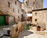 Un vicolo stretto con scale di pietra e case antiche in tufo, un'atmosfera da piccola Gerusalemme.
