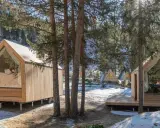 Accoglienti alloggi particolari nel Lazio, con cabine in legno e ampie vetrate immerse nel bosco innevato.