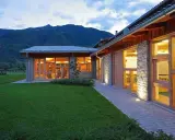 Agriturismi con fattoria immersi nel verde, con architettura in pietra e legno, illuminati al tramonto.
