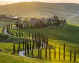 Colline ondulate del Val d'Orcia, cipressi lungo una strada tortuosa, un casale in pietra. Perfetto per cosa vedere in 3 giorni.