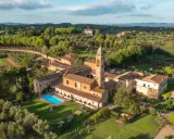 Un'antica dimora con campanile e una splendida piscina toscana, immersa nel verde delle colline.