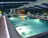 Piscina coperta con lettini e cascate d'acqua, un'oasi di relax tra le migliori spa in Umbria.