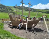 Un grande galeone di legno su un prato verde, perfetto per agriturismi per bambini in Piemonte. Bambini giocano a bordo.