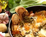 Uova cotte in padella con verdure, patate, aglio, peperoncino e pane tostato. Un piatto rustico e saporito, perfetto per una colazione o un pasto veloce.