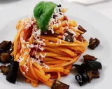Pasta con melanzane fritte e ricotta salata, un classico su cosa mangiare in Sicilia. Un piatto gustoso e colorato.
