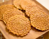 Pizzelle, dolci tradizionali abruzzesi, su un piatto di legno.