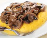 Polenta con funghi trifolati, un classico tra i cibi tipici del Trentino Alto Adige, pronta per essere gustata.