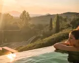 Relax in una piscina a sfioro con vista sulle colline toscane al tramonto. Un'atmosfera perfetta per San Valentino in Toscana.