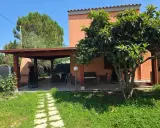 Veranda con tavolo e sedie, barbecue e alberi da frutto. Un angolo di pace tra i migliori agriturismi Sardegna sud.