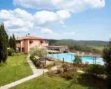 Un agriturismo in Toscana a Pasqua, con piscina azzurra e colline verdi sullo sfondo.