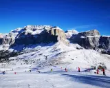 Piste innevate e maestose vette per decidere dove andare a sciare in Trentino. Sciatori e impianti di risalita animano il paesaggio.
