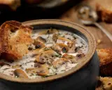Una cremosa zuppa di funghi toscana, arricchita da erbe aromatiche e servita con crostini di pane abbrustolito.