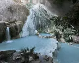 Cascate termali naturali a San Filippo, Toscana, con acque azzurre che scorrono su rocce calcaree.