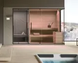 Moderna spa per famiglie con sauna in legno, doccia e vista panoramica su un paesaggio innevato.