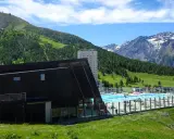 Una splendida piscina in montagna in Piemonte, con vista su verdi colline e cime innevate.