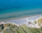 Spiaggia attrezzata con ombrelloni blu, ideale per campeggi in Toscana sul mare per bambini. Acqua cristallina e gente che si gode il sole.