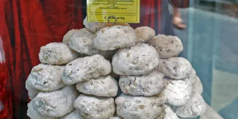 Dolce senese: cavallucci, biscotti rustici con noci e agrumi, impilati su un piatto di vetro.