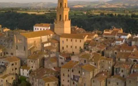 Pitigliano, la "piccola Gerusalemme", si staglia su una rupe tufacea, con le sue case antiche e la torre campanaria che domina il paesaggio.