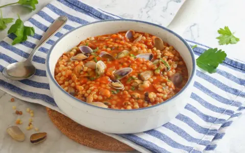 Fregola sarda con vongole e cozze, un classico da provare per scoprire cosa mangiare in Sardegna.