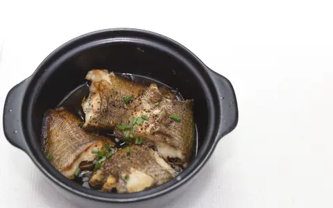Pezzi di pesce dorato in umido, guarniti con erba cipollina, un assaggio dei piatti tipici Pescara.