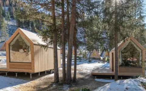 Accoglienti alloggi particolari nel Lazio, con cabine in legno e ampie vetrate immerse nel bosco innevato.