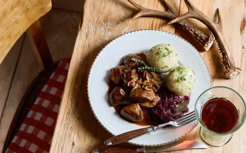 Un piatto di selvaggina in umido con canederli e cavolo rosso, perfetto per una dolceforte ricetta autunnale.