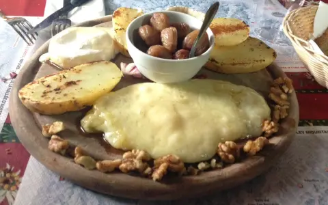 Piatto con formaggio fuso, patate arrosto, noci e cipolline. Un assaggio dei piatti tipici Valle d'Aosta.