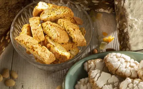 Biscotti e amaretti, deliziosi dolci toscani, su un tavolo di legno.