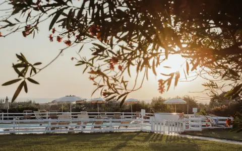 Tramonto dorato su una piscina con lettini e ombrelloni, un'oasi di pace tra i **posti romantici Toscana**.