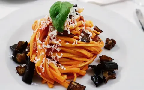 Pasta con melanzane fritte e ricotta salata, un classico su cosa mangiare in Sicilia. Un piatto gustoso e colorato.