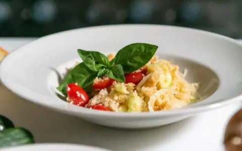 Panzanella, un classico dei piatti tipici toscani estivi, con pomodorini, cetrioli e basilico fresco.