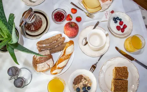 Un ricco e genuino **colazione contadina** con pane integrale, marmellata, frutta fresca, yogurt, succo d'arancia e dolcetti.