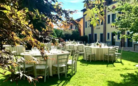 Tavoli apparecchiati in giardino, un'idea perfetta per cosa fare in campagna: un banchetto all'aperto sotto il sole.