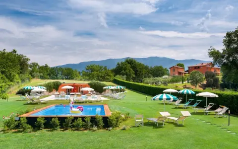 Agriturismi per bambini con piscina e gonfiabile a forma di unicorno, circondati da verde e colline.