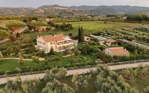 Incantevole masseria in Toscana, con piscina, giardini curati e uliveti, immersa nel verde delle colline.