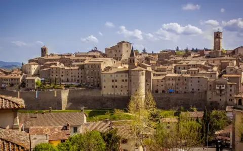 Panoramica di un borgo medievale toscano, con case in pietra e tetti in cotto, che si estende su una collina. Una dettagliata cartina borghi toscana potrebbe mostrare questo luogo.
