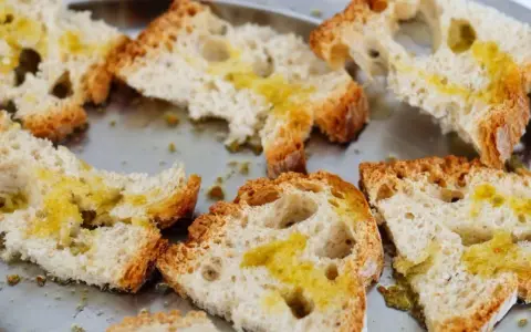 Fettunta cos'è? Fette di pane tostato condite con olio d'oliva, un classico antipasto toscano.