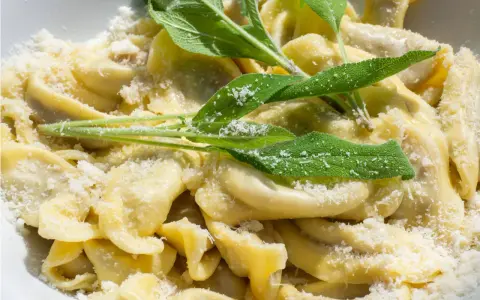 Casoncelli alla bergamasca, un piatto tipico bergamasco, conditi con burro fuso, salvia e abbondante grana.